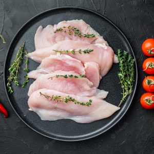 pieces-raw-uncooked-chicken-fillet-black-background-top-view-flat-lay_249006-19656